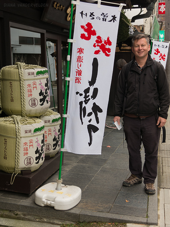 Arie at a sake brewery. On the left are sake barrels.